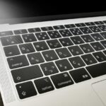 Close-up of a silver laptop keyboard showing black keys with 'control', 'option', and 'command' labels, part of the trackpad area visible below