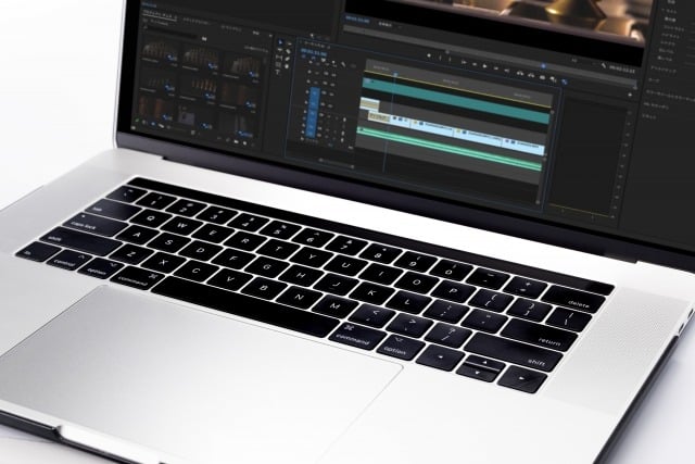 Silver laptop displaying a video editing timeline with multiple tracks on the screen