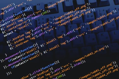 Close-up of a keyboard with colorful code snippets overlaid on the keys, representing programming.