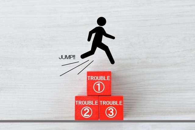 Stick figure jumping over three red blocks labeled TROUBLE 1, 2, and 3